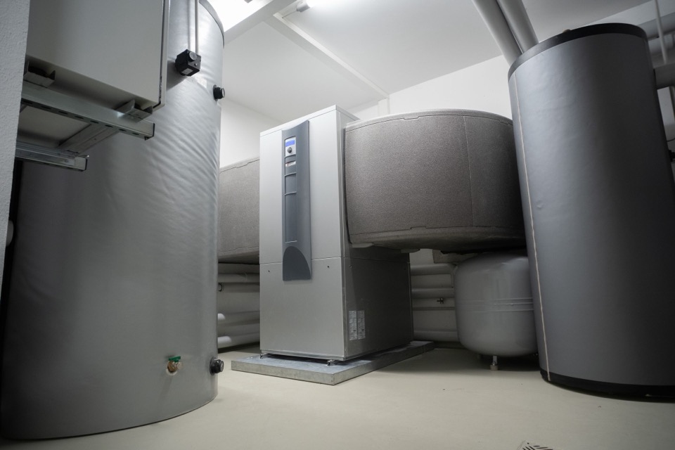 Technische ruimte met een binnenunit en twee grijze warmwatervaten